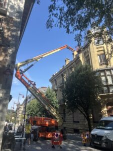 Plataforma elevadora trabajando en la rehabilitación de una fachada en la ciudad
