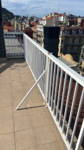 Barandilla blanca sobre terraza con vista a edificios