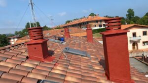 Tejado con chimeneas de ladrillo rojo y paneles solares