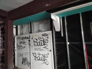 Pared de obra con grafitis visibles y elementos de construcción