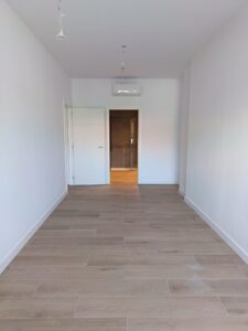 Espacio interior con suelo de madera clara y paredes blancas