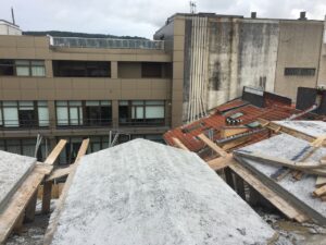 Cubierta en proceso de rehabilitación, con estructuras de madera y material sobre la superficie.