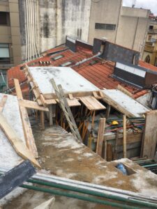 Cubierta en proceso de rehabilitación, con estructura de madera y materiales visibles como tablones y cemento