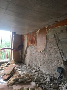 Pared en proceso de desmantelamiento con escombros en el suelo