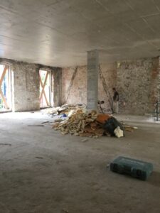 Espacio en la obra con escombros y trabajadores en actividad