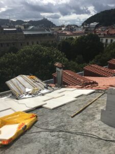 Tejas de una cubierta en proceso de reforma con vistas a una ciudad