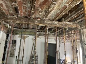 Estructura de paredes y techos en proceso de rehabilitación con andamios y materiales visibles