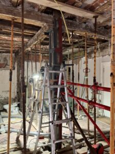 Estructura metálica en una obra con andamios y un escalera en el centro