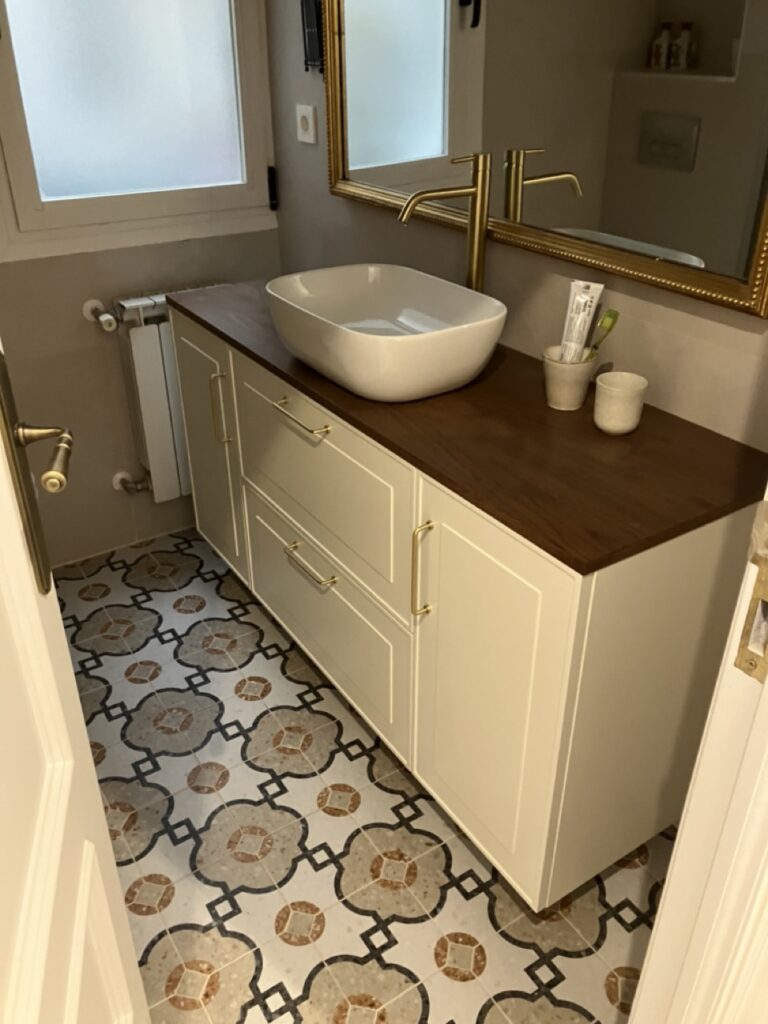 Mueble de baño en color blanco con lavabo sobreencimera y detalles en madera