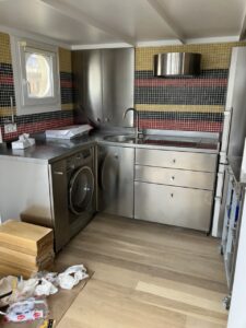 Cocina con muebles de acero inoxidable y azulejos coloridos en las paredes