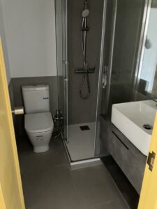 Baño reformado con ducha de cristal, sanitario y lavabo moderno