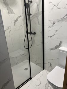 Baño moderno con ducha de vidrio y azulejos de mármol