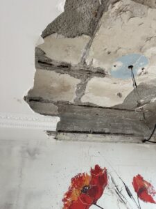 Techo dañado con revestimiento caído y daños en la estructura visible
