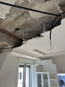Techo en mal estado con partes derrumbadas en una habitación en reforma
