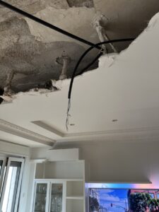 Techo con daños visibles y cable expuesto en una obra de reforma