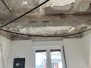 Techo con daños visibles y cables expuestos en una obra de rehabilitación