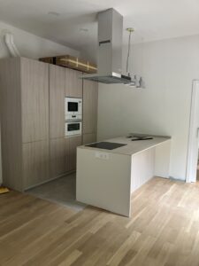 Cocina moderna con mobiliario de madera clara y electrodomésticos empotrados