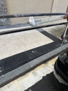 Rampa de acceso con pavimento texturizado y barandilla en una obra de reforma