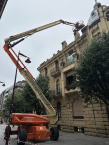 Plataforma elevadora trabajando en la parte superior de un edificio antiguo