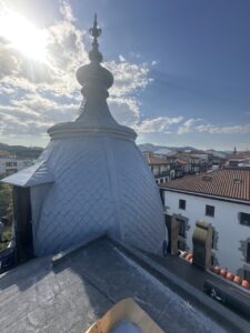 Cúpula de techo con tejas en rehabilitación y vista de urbanización