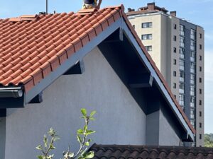 Cubierta de vivienda con tejas rojas y trabajador en la parte superior