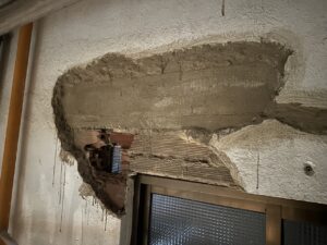 Pared con enlucido imperfecto y ladrillos expuestos en una obra