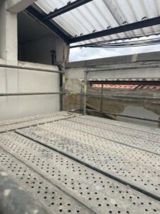 Andamios instalados en el interior de una obra con paredes de yeso