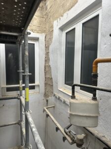 Ventanas nuevas en una obra con andamiaje y tuberías visibles