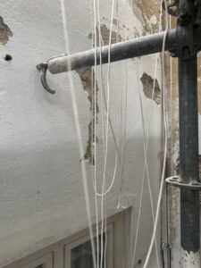 Pared en proceso de rehabilitación con tubos y cuerdas