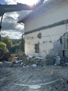 Excavadora realizando trabajo de rehabilitación en el exterior de una vivienda