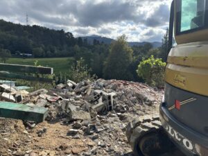 Excavadora amarilla al lado de escombros en un terreno de obra