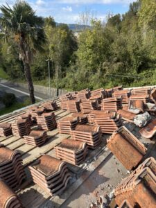 Tejas de terracota apiladas sobre una cubierta en proceso de reforma