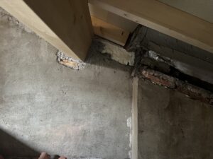 Pared de obra con cemento y ladrillo expuesto en un espacio de reforma
