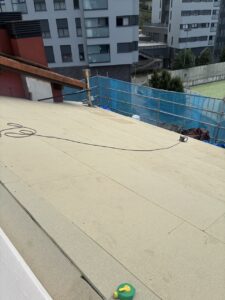 Cubierta de obra con material de impermeabilización y herramientas visibles