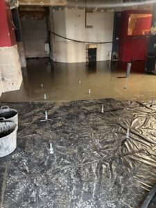 Suelo de obra en proceso de instalación con cemento fresco y materiales de construcción.