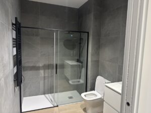 Baño con ducha de cristal y sanitarios contemporáneos