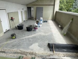 Terraza con suelo de hormigón y materiales de construcción dispuestos para el trabajo