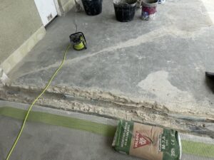 Superficie de suelo en proceso de reforma con material y herramientas visibles
