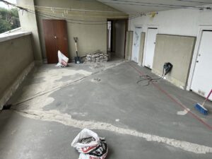 Suelo de obra con cemento en proceso de rehabilitación, herramientas y materiales visibles