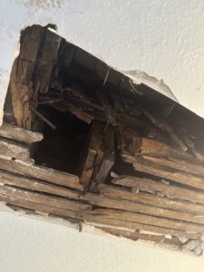 Estructura de madera dañada en un techo, mostrando la descomposición y el desgaste del material