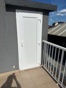 Puerta blanca que da acceso a la azotea en un edificio