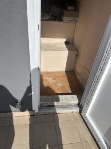 Espacio interior con suelo de baldosas, paredes sin terminar y sombra proyectada