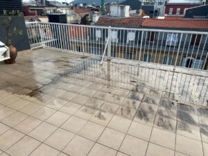 Terraza con baldosas cerámicas mojadas y con manchas en la superficie