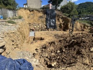 Excavación en terreno con maquinaria pesada y materiales de construcción a la vista