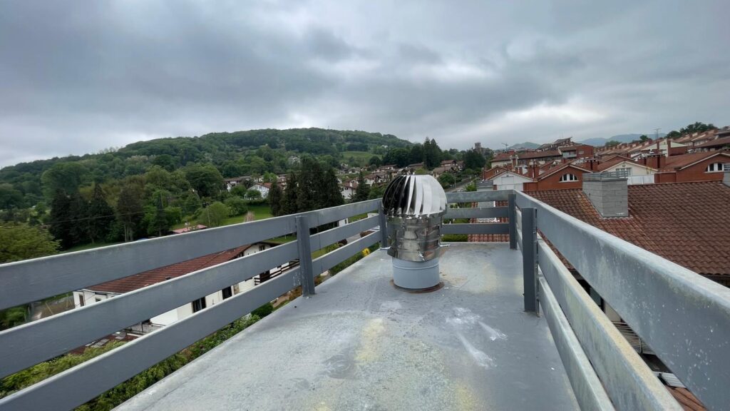 Chimenea en un tejado con vista del paisaje