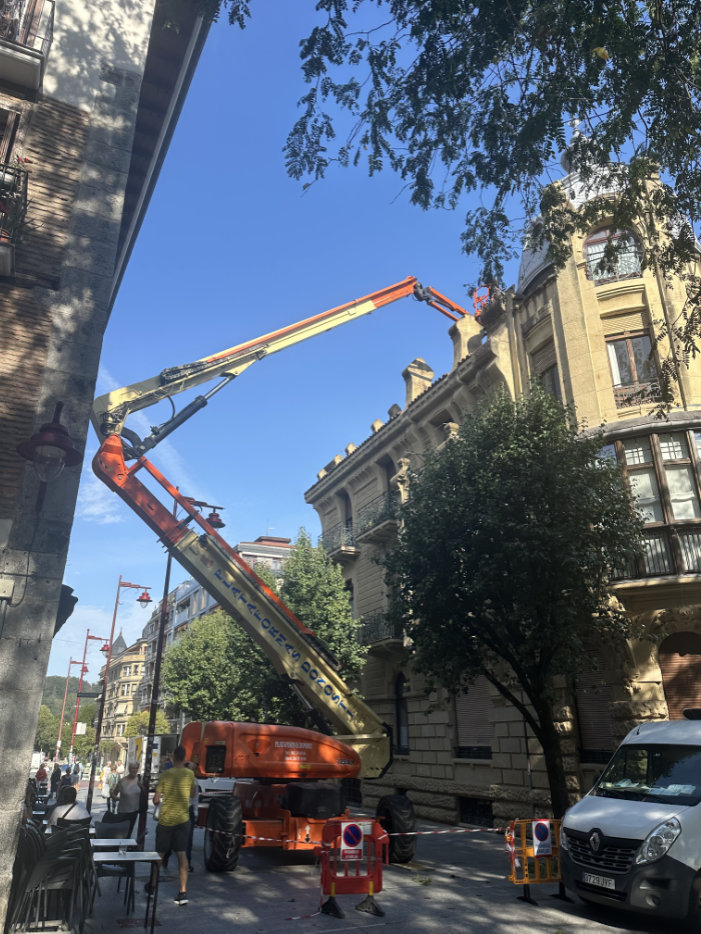 Grúa en la calle trabajando en la fachada de un edificio
