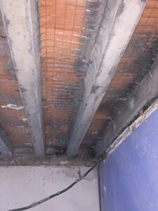 Estructura de techo en obra con vigas expuestas y malla de refuerzo visible