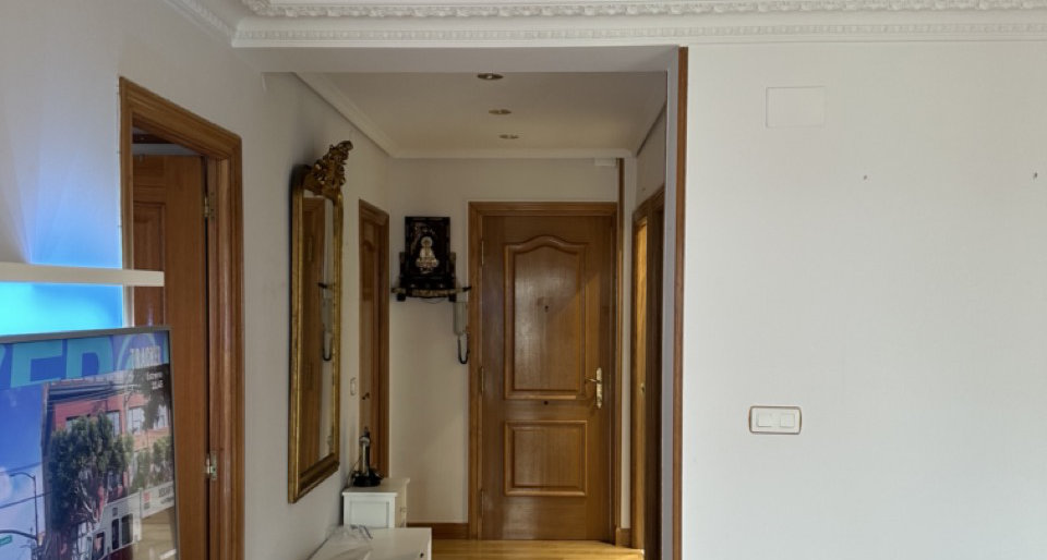 Pasillo con paredes pintadas y puertas de madera en una vivienda reformada