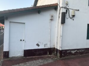 Pared blanca con puerta y esquina de un edificio en la calle