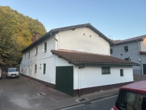 Fachada de una casa rehabilitada pintada de blanco con tejado de teja